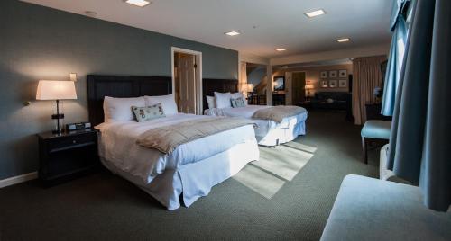 um quarto de hotel com duas camas e uma cadeira em The Inn at Scituate Harbor em Scituate