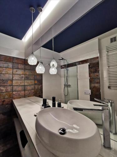 a bathroom with a white sink and a tub at Apartamenty Orkana in Bielsko-Biała
