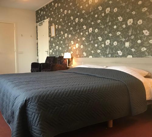 1 dormitorio con 1 cama con pared de flores en Hotel Norg en Norg
