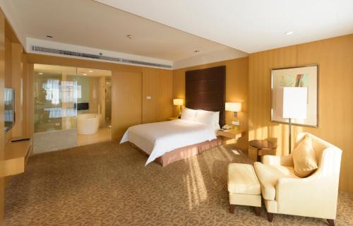 a large hotel room with a bed and a chair at Holiday Inn Shijiazhuang Central by IHG in Shijiazhuang