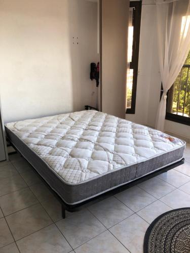 Bett in einem Zimmer mit einer großen Matratze in der Unterkunft Studio cabine Toi et Moi à 30 m de la plage de Valras centre in Valras-Plage