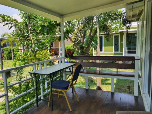 a table and a chair on a porch at Phalagoon Resort in Ban Chang
