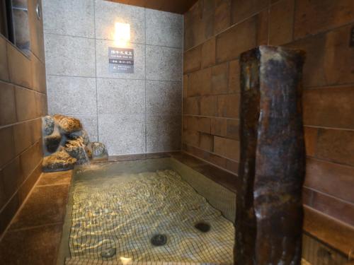 
a bath room with a statue of a man in it at Dormy Inn Ikebukuro in Tokyo
