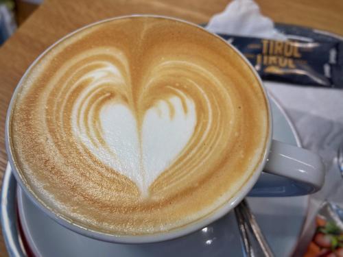 a cup of coffee with a heart painted on it at Hotel Tirol in Ischgl