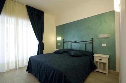 1 dormitorio con cama y pared verde en Atlantis Inn Roma en Roma
