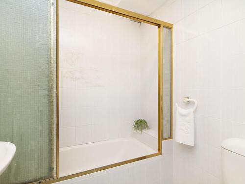 a bathroom with a shower with a glass door at Coral Gardens Unit 2 in Coolangatta