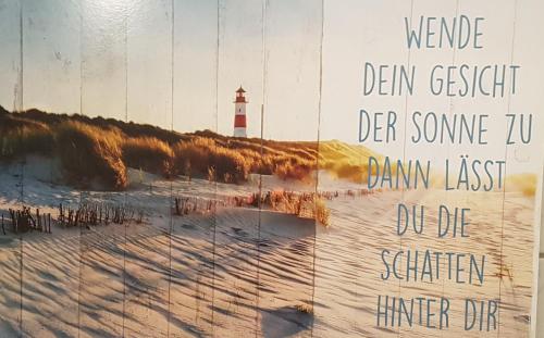 a picture of a beach with a lighthouse at Ankerplatz, Am Hafen Ost 10 in Carolinensiel
