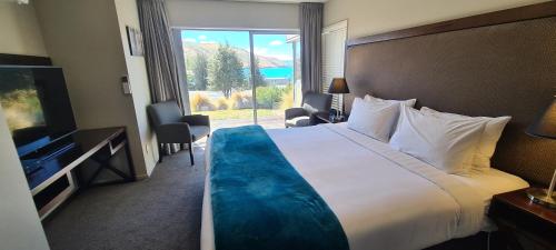 a hotel room with a large bed and a large window at Peppers Bluewater Resort in Lake Tekapo
