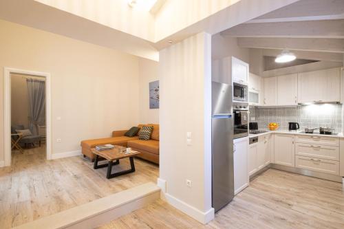 een keuken en een woonkamer met een bank en een tafel bij Melina's Urban Retreat in Corfu-stad