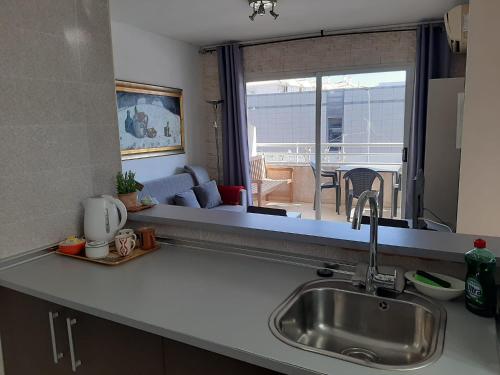 uma cozinha com um lavatório e vista para uma sala de estar em Albir Sunshine Apartments em Albir