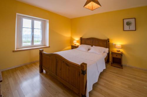 a bedroom with a large bed and a window at La Clé des Champs des Abers in Saint-Pabu