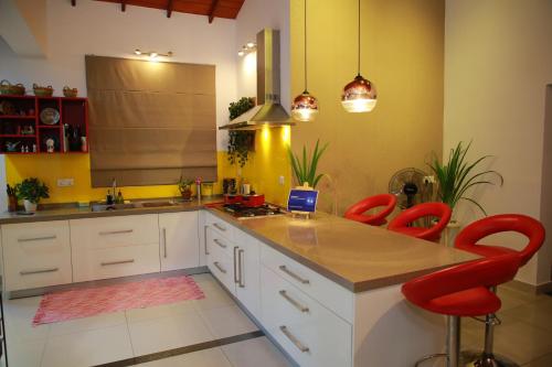 a kitchen with red chairs and a laptop on a counter at Colombo Orchid Villa in Colombo