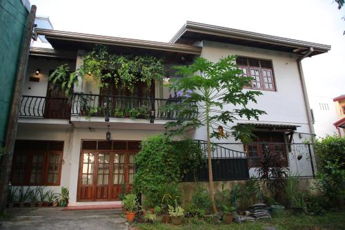 a house with a balcony and a tree at Colombo Orchid Villa in Colombo