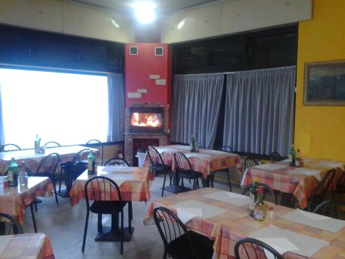 サン・ジュリアーノ・ミラネーゼにあるLocanda La Cascinaのテーブルと椅子、暖炉のあるレストラン