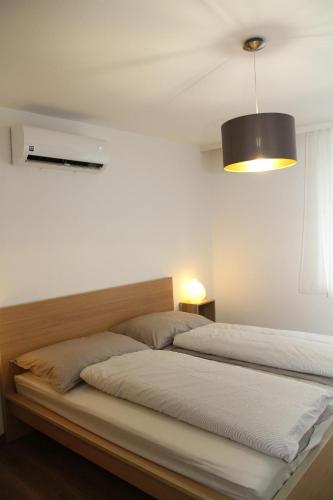 a bedroom with two beds and a black lamp at Ferienwohnung Illy in Illmitz