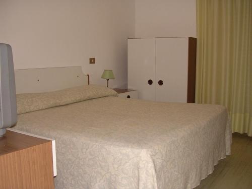 a bedroom with a bed and a cabinet and a television at Albergo Tenda Verde in Falconara Marittima