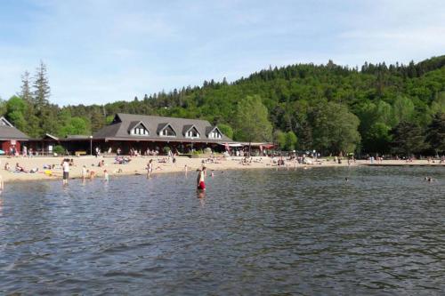 un groupe de personnes nageant dans l'eau près d'une plage dans l'établissement CURE THERMALE OU VACANCES D'ETE AU MONT DORE, à Le Mont-Dore