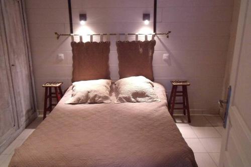 a bedroom with a bed with two pillows on it at CURE THERMALE OU VACANCES D'ETE AU MONT DORE in Le Mont-Dore