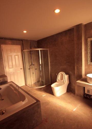 a bathroom with a tub and a toilet and a sink at G2 Boutique Hotel in Chiang Mai