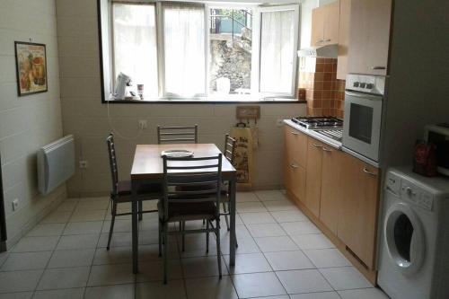 une cuisine avec une table et des chaises dans une cuisine dans l'établissement CURE THERMALE OU VACANCES D'ETE AU MONT DORE, à Le Mont-Dore