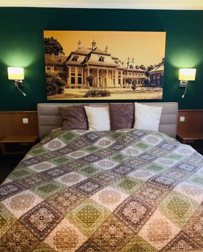 a bedroom with a bed with a picture on the wall at Restaurant und Pension Zur Puppenstube in Stolpen
