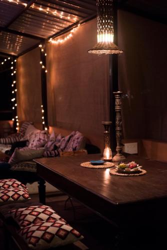 a living room with a table and a lamp at Anjuna Hideout in Anjuna