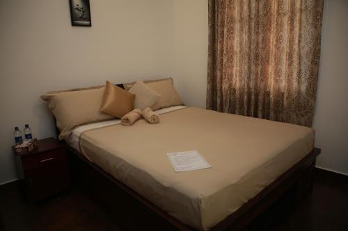 a bed with a teddy bear sitting on it at Colombo Orchid Villa in Colombo