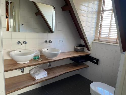 a bathroom with two sinks and a mirror at Slot Oostende in Goes