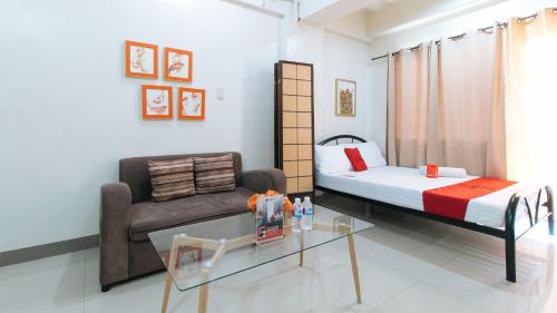 a room with a bed and a couch and a table at RedDoorz at Kassel Residences Parañaque in Manila