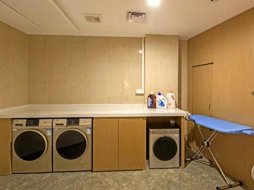 a laundry room with a counter and a washing machine and a chair at GreenTree Eastern Chaoyang Plaza Hotel in Nanning