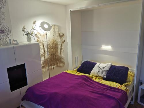 a bedroom with a bed with a purple blanket at Fewo-Harz-Uraub in Altenau