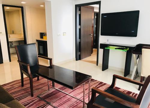 a living room with a table and a tv at Golden Tulip City Centre Gurgaon in Gurgaon