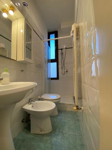 Ca' Santa Marta Apartment في البندقية: حمام ابيض مع مرحاض ومغسلة