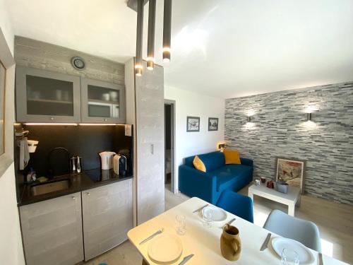 a living room with a table and a blue couch at Hôtel Rent in Megève