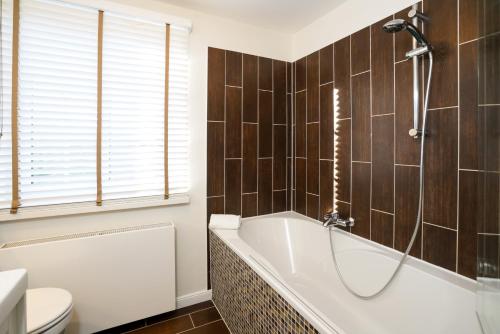 Ferienhaus Frieda Sylt في تينوم: حمام مع حوض استحمام ومرحاض