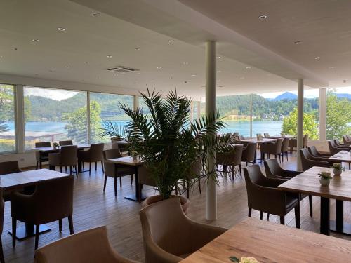 a restaurant with tables and chairs and a large window at Hotel Marolt Dependance in Sankt Kanzian