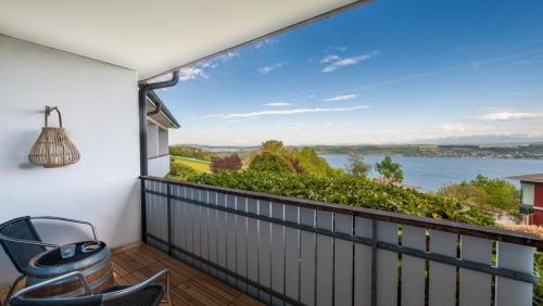 a balcony with chairs and a view of the water at Le Mont-Vully - Hôtel Restaurant in Haut-Vully