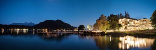 a view of a building on a lake at night at Hotel Marolt Dependance in Sankt Kanzian
