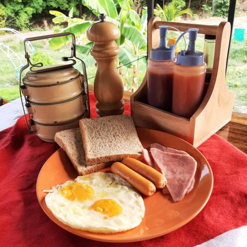 a plate of breakfast food with eggs ham and toast at Rapeepat Residential and Resort in Ban Nong Khaman