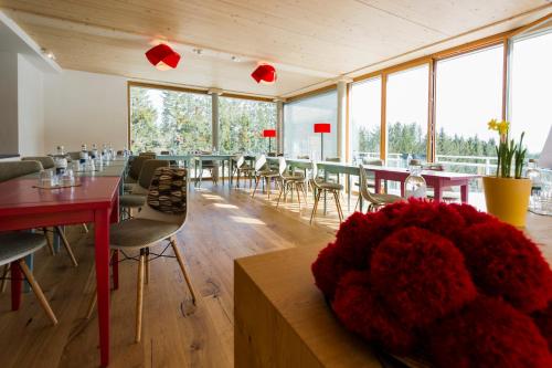 a dining room with tables and chairs and windows at Berghaus Freiburg - Appartement Hotel auf dem Schauinsland in Oberried