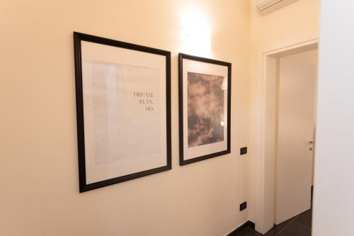 two framed pictures on a wall in a hallway at Cà Sottomarina gli Appartamenti in Centro Apartsuite in Sottomarina