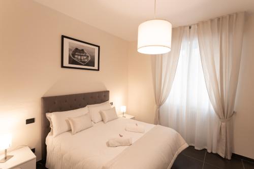 a bedroom with a white bed and a window at Cà Sottomarina gli Appartamenti in Centro Apartsuite in Sottomarina