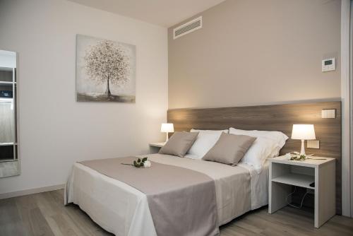 1 dormitorio con 1 cama grande y 1 mesa con 2 lámparas en Camelot Appartamenti - Business e Holiday en San Martino Buon Albergo