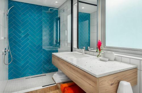 a bathroom with a large sink and a blue wall at Sables d'Or Luxury Apartments in Beau Vallon