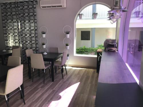 una sala da pranzo con tavolo, sedie e finestra di Casas de Luanda GH-Miramar a Luanda