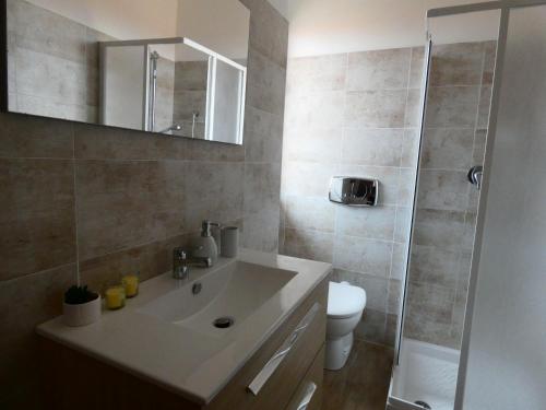 a bathroom with a sink and a toilet and a mirror at B&B MaDie in Castelsardo