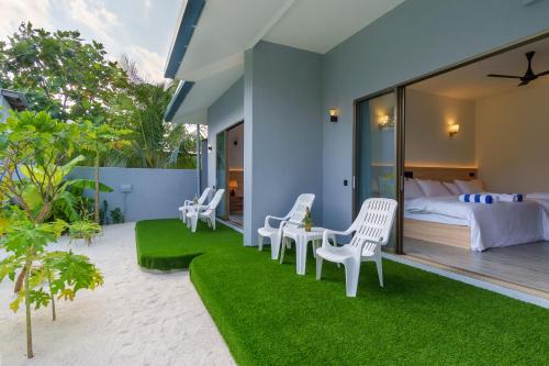La Palma Villa في أوكولهاس: غرفة نوم بسرير وبعض الكراسي والعشب