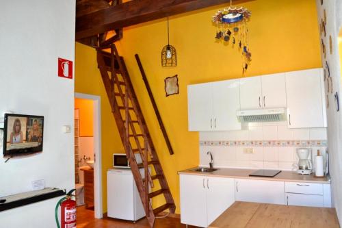 a kitchen with white cabinets and a wooden ladder at Los Tres Soles in Silleda