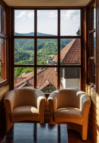 a living room with two couches and a large window at Konačište Osmica in Mokra Gora