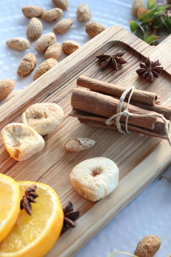 a wooden cutting board with donuts and spices and orange slices at Hotel Grotta in Naxos Chora
